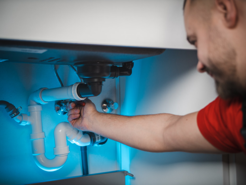 Plumber working on kitchen sink trap